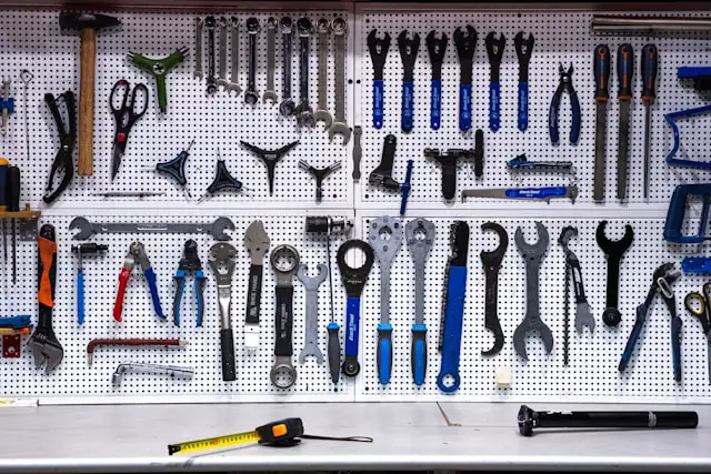 Wall of spanners, pliers and hand tools on a pegboard